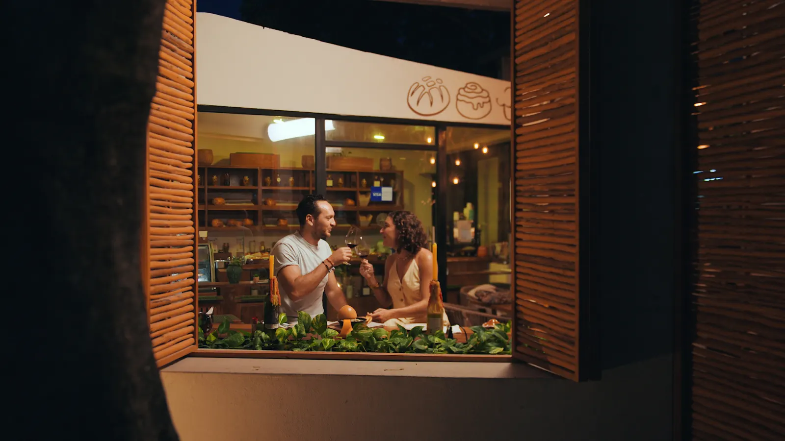 Fachada de Mylo de noche con comensales en la ventana